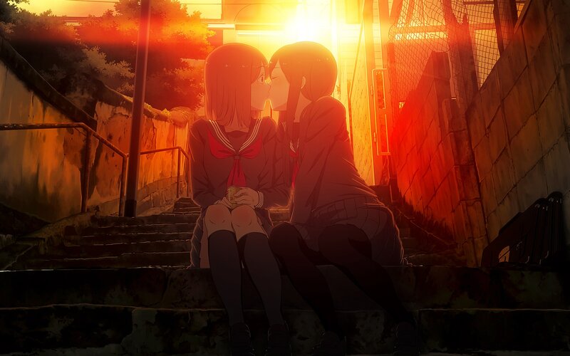 Two girls kissing at sunset