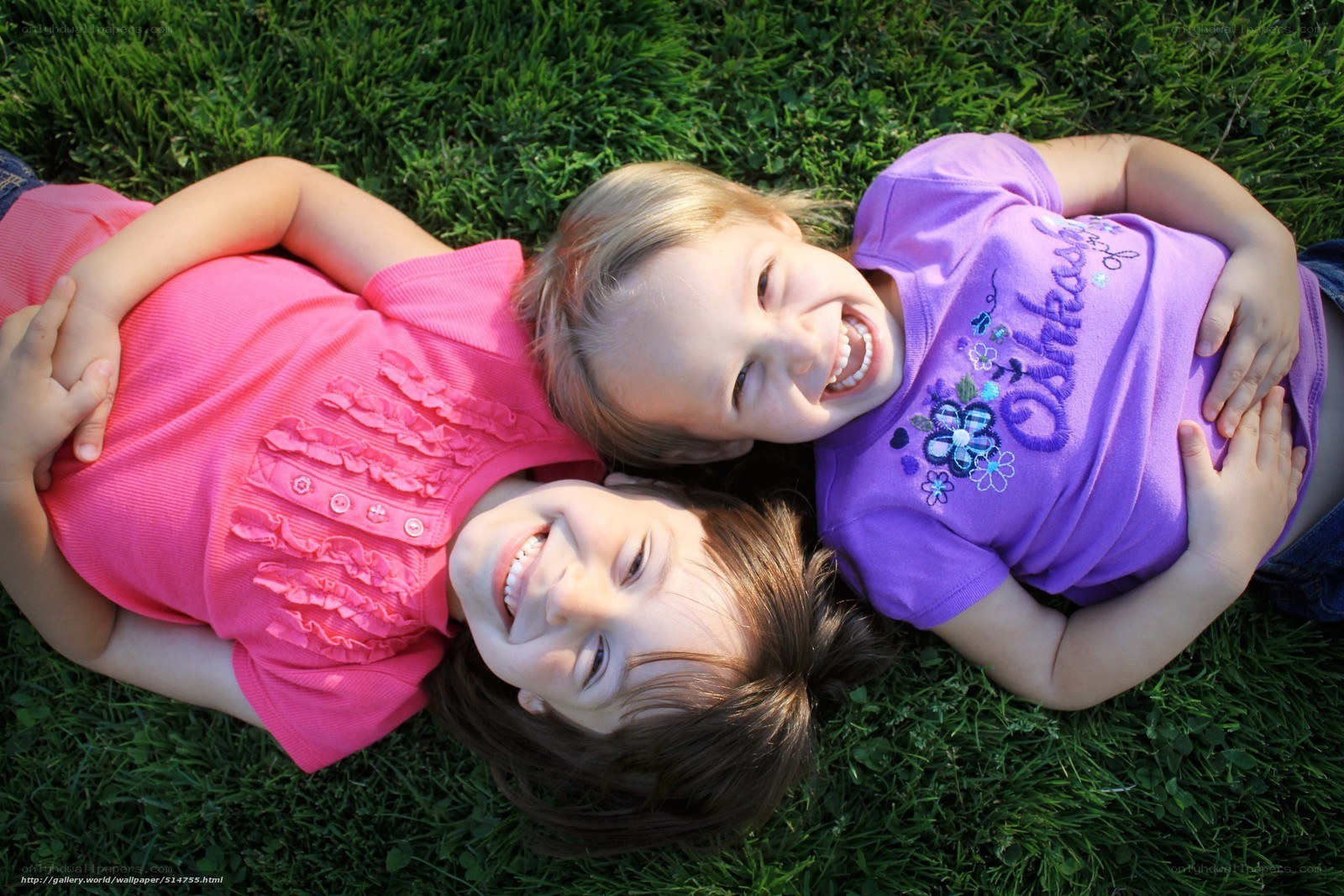two girls lying on grass