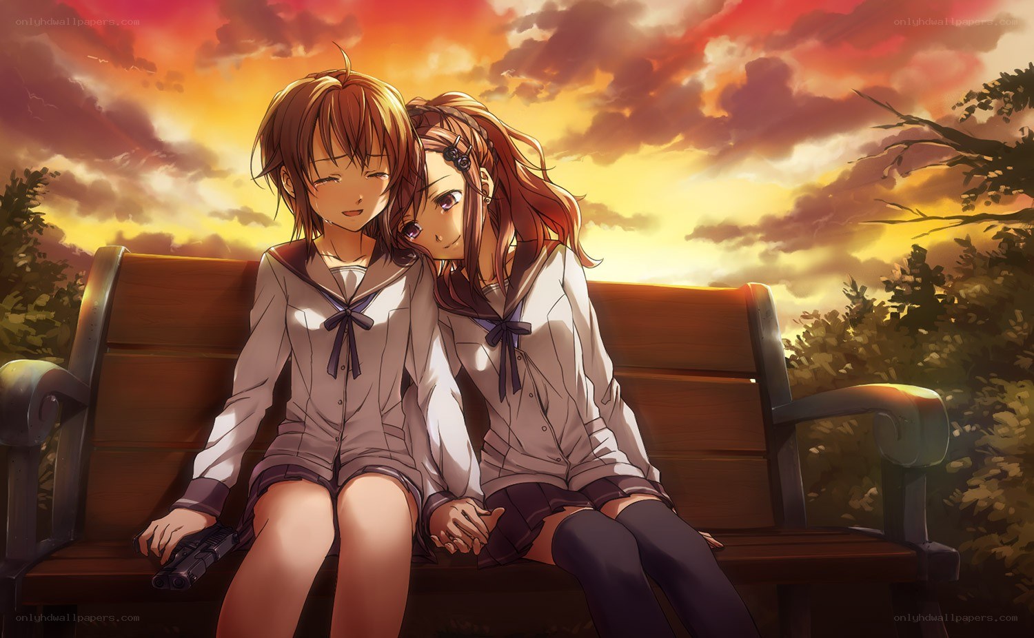 Two girls on a bench at sunset