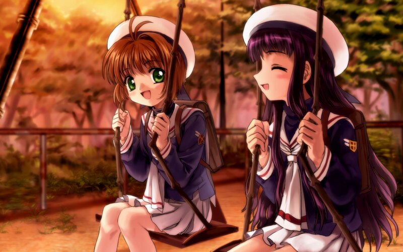 two girls on swings at sunset