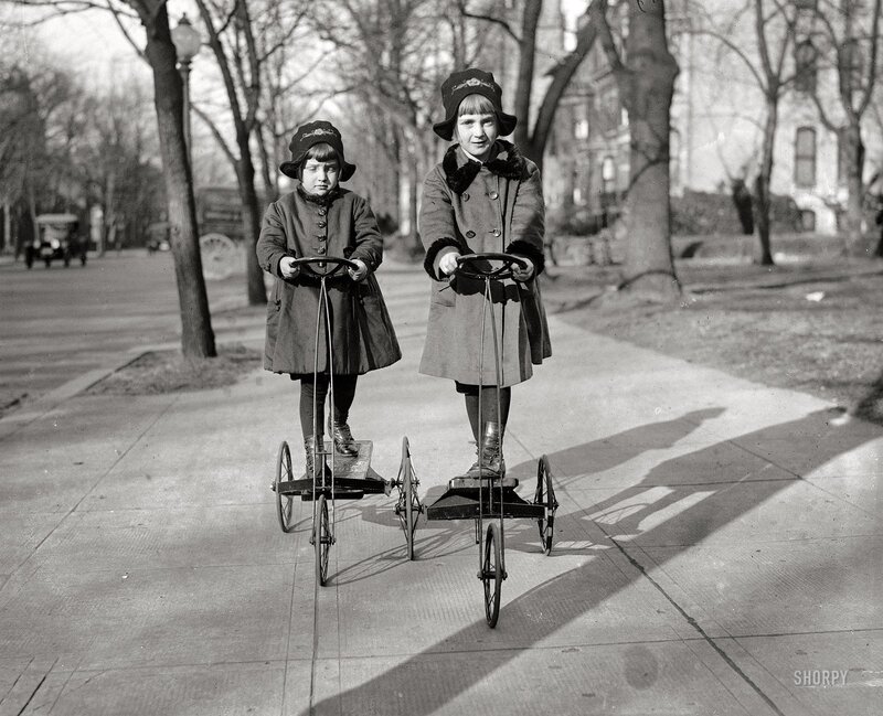 Two girls on tricycles
