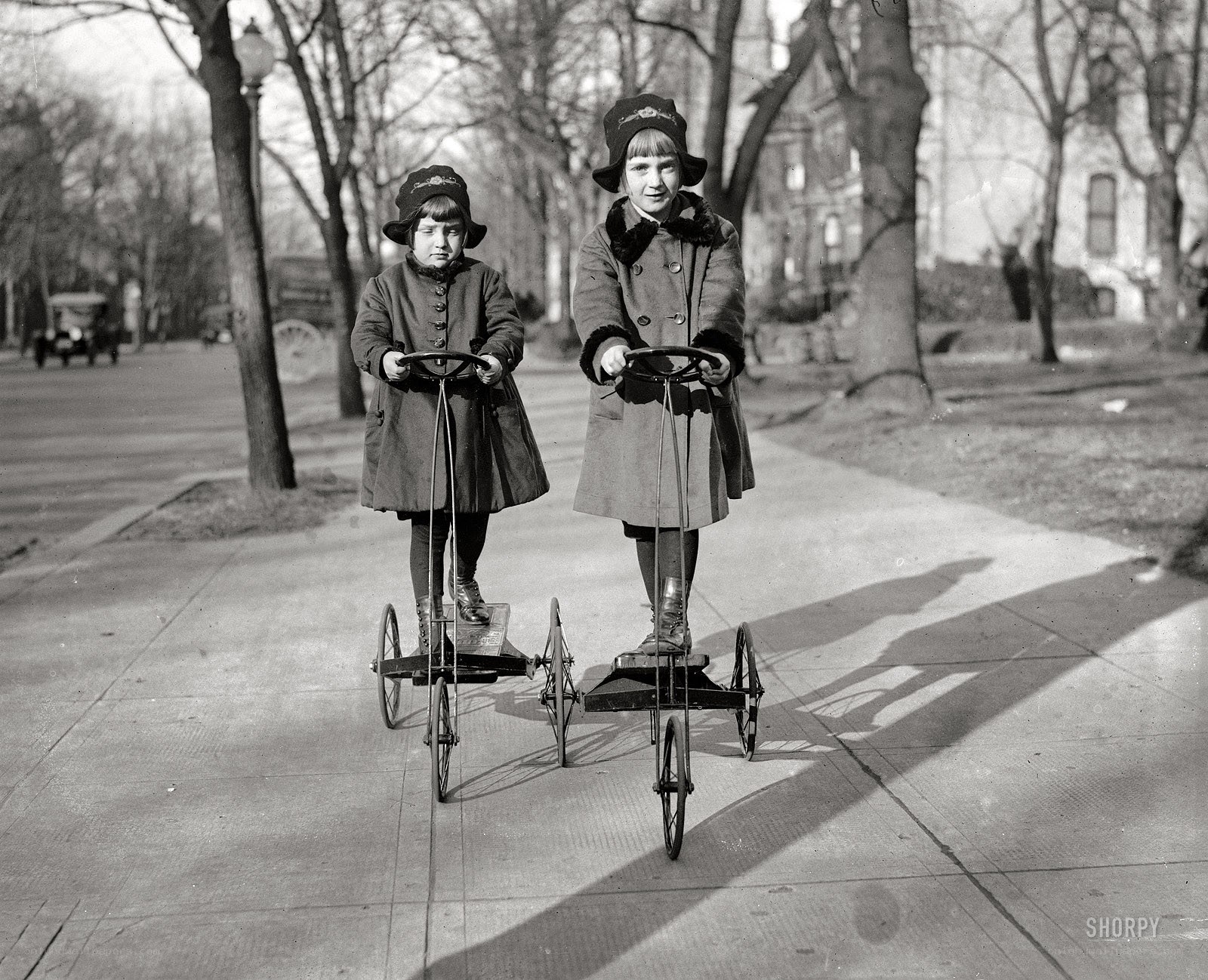 Two girls on tricycles