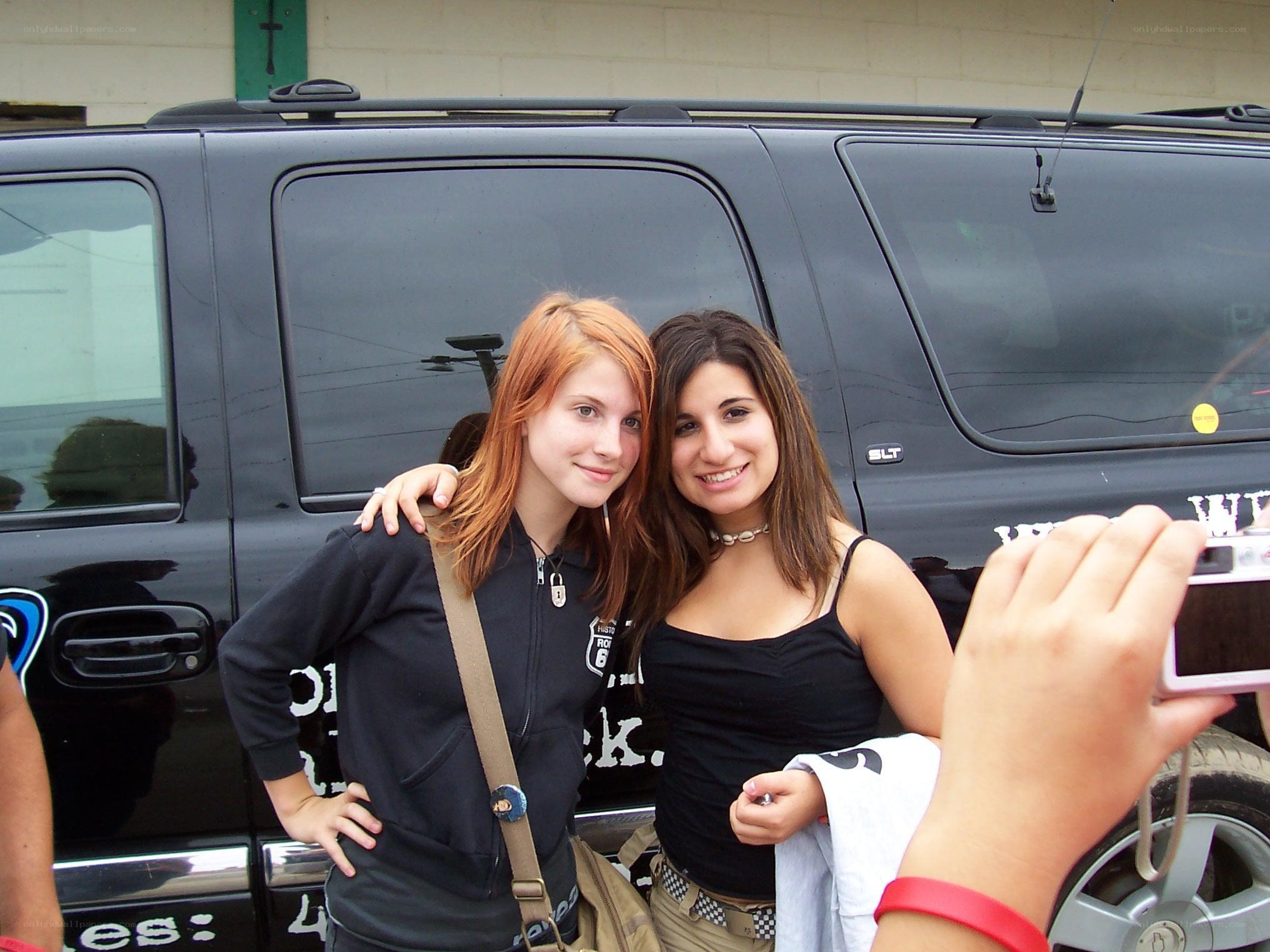 Two girls posing by a black SUV