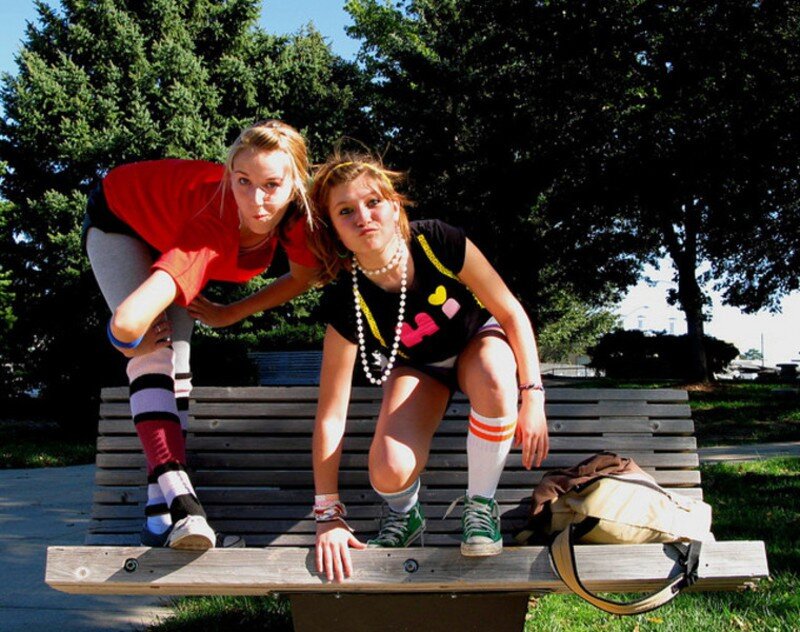 Two girls posing on a bench
