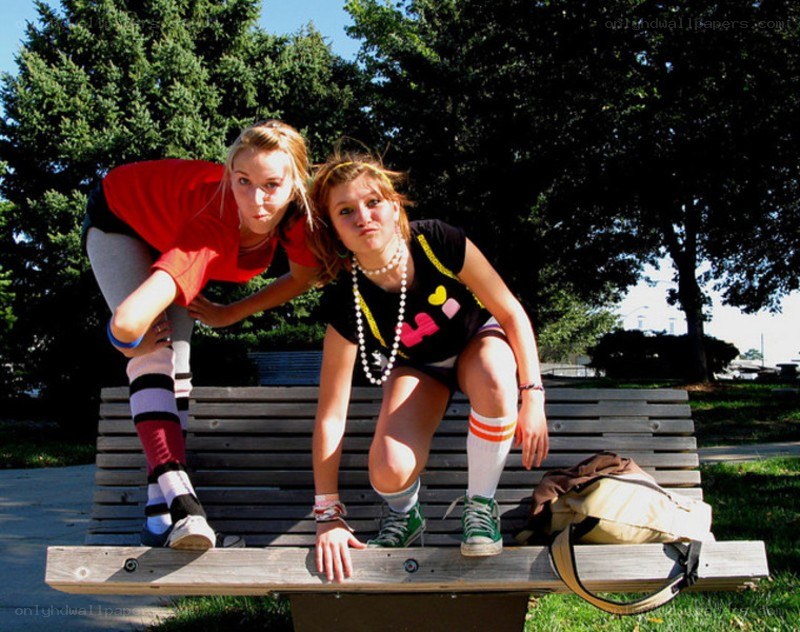 Two girls posing on a bench