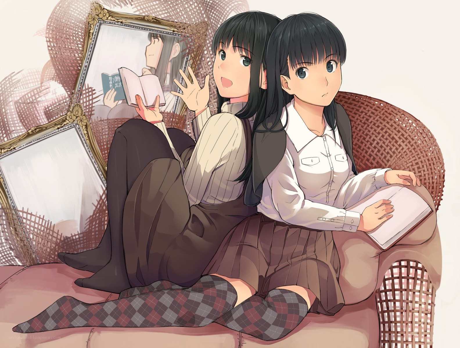 Two girls reading on a wicker chair