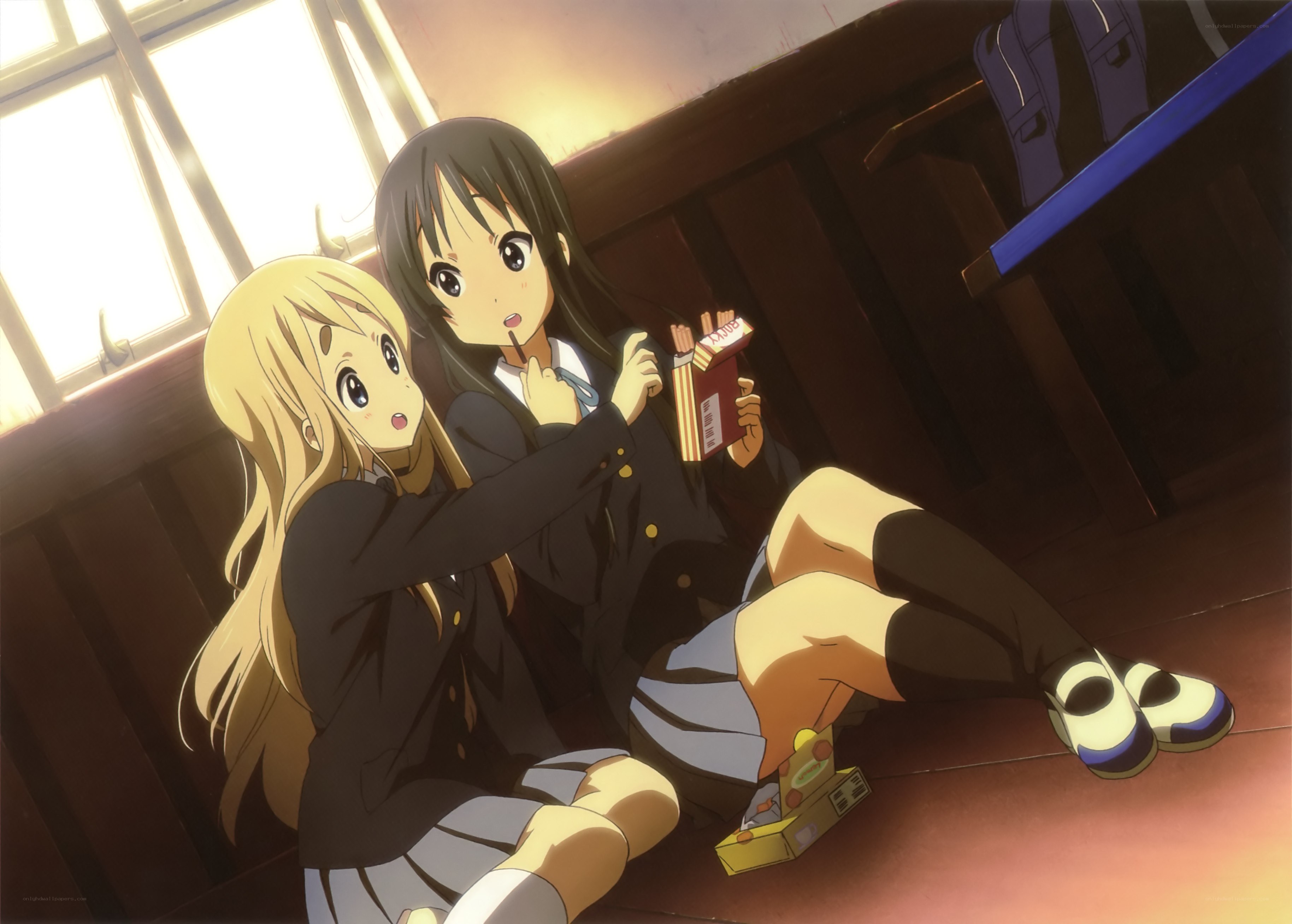 Two girls sharing snacks in a classroom