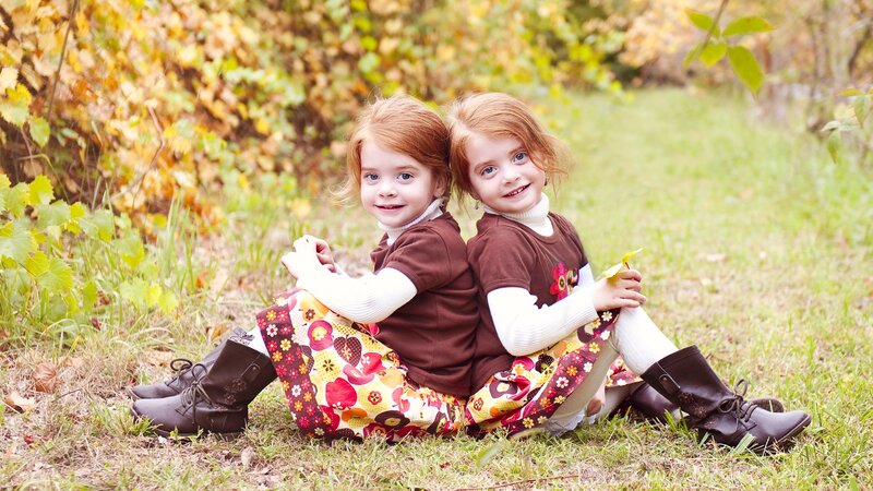 Two Girls Sitting Back-to-back — Brown