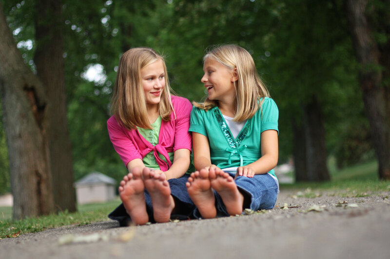 Two Girls Sitting Barefoot