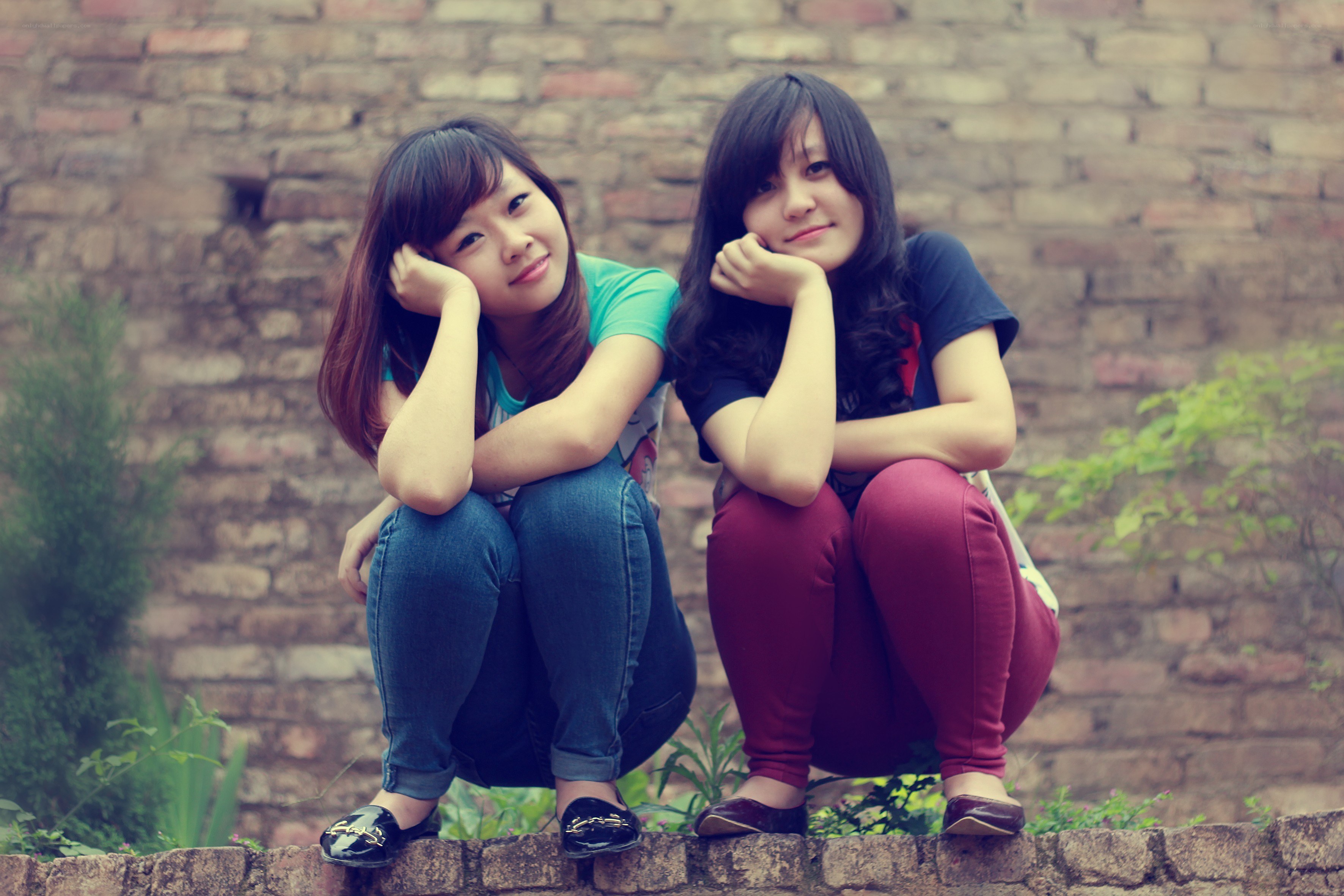 Two girls sitting on a wall