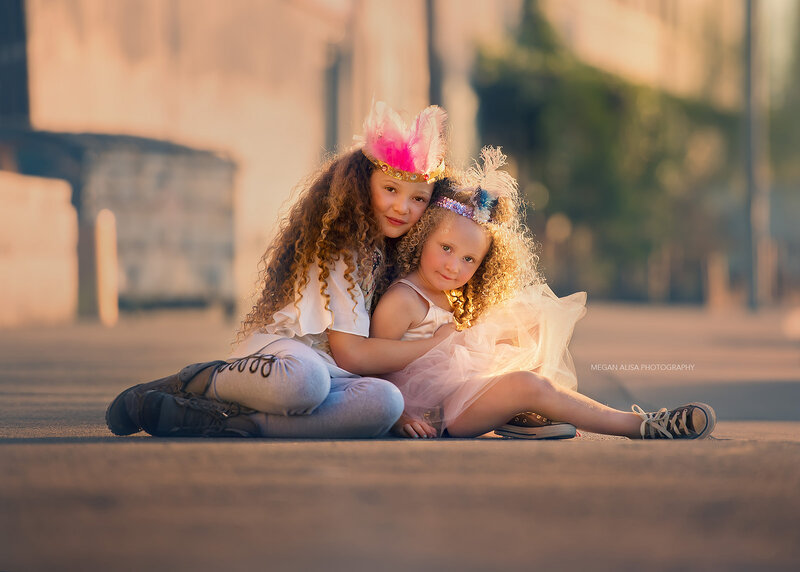 Two Girls Sitting on Pavement
