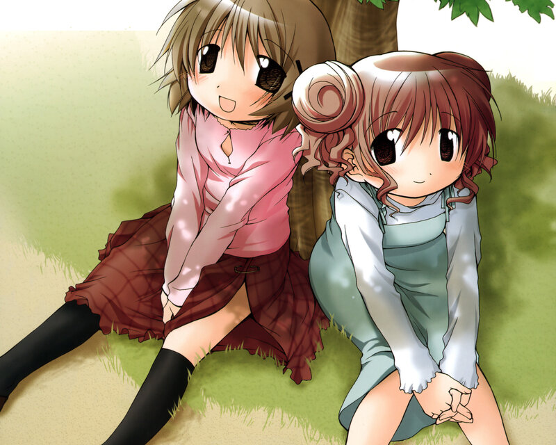 Two girls sitting under a tree