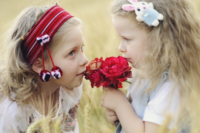 Two Girls Smelling Flowers — Red