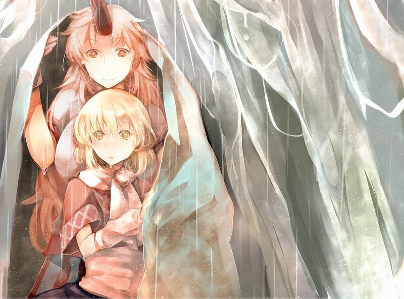 Two girls under a blanket in the rain