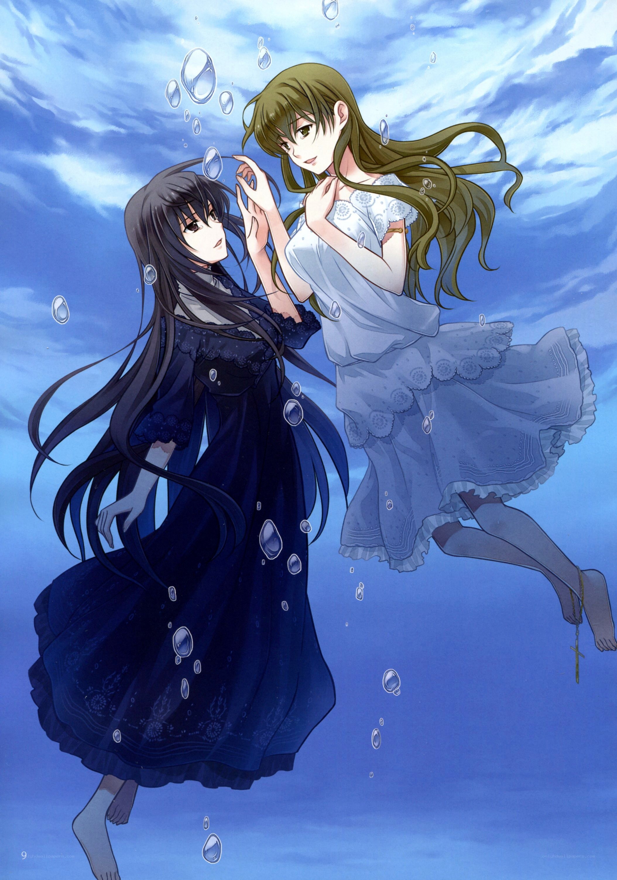 Two girls underwater in dresses