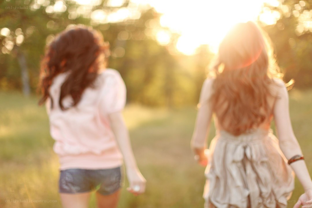 two girls walking in a field