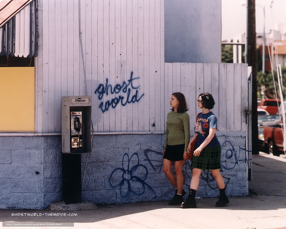 two girls walking past phone booth