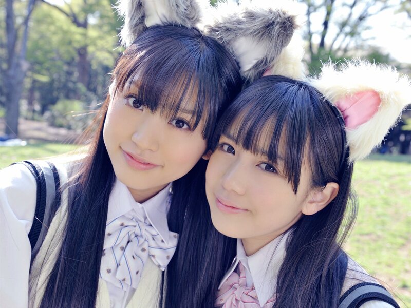 Two girls with animal ears in a park