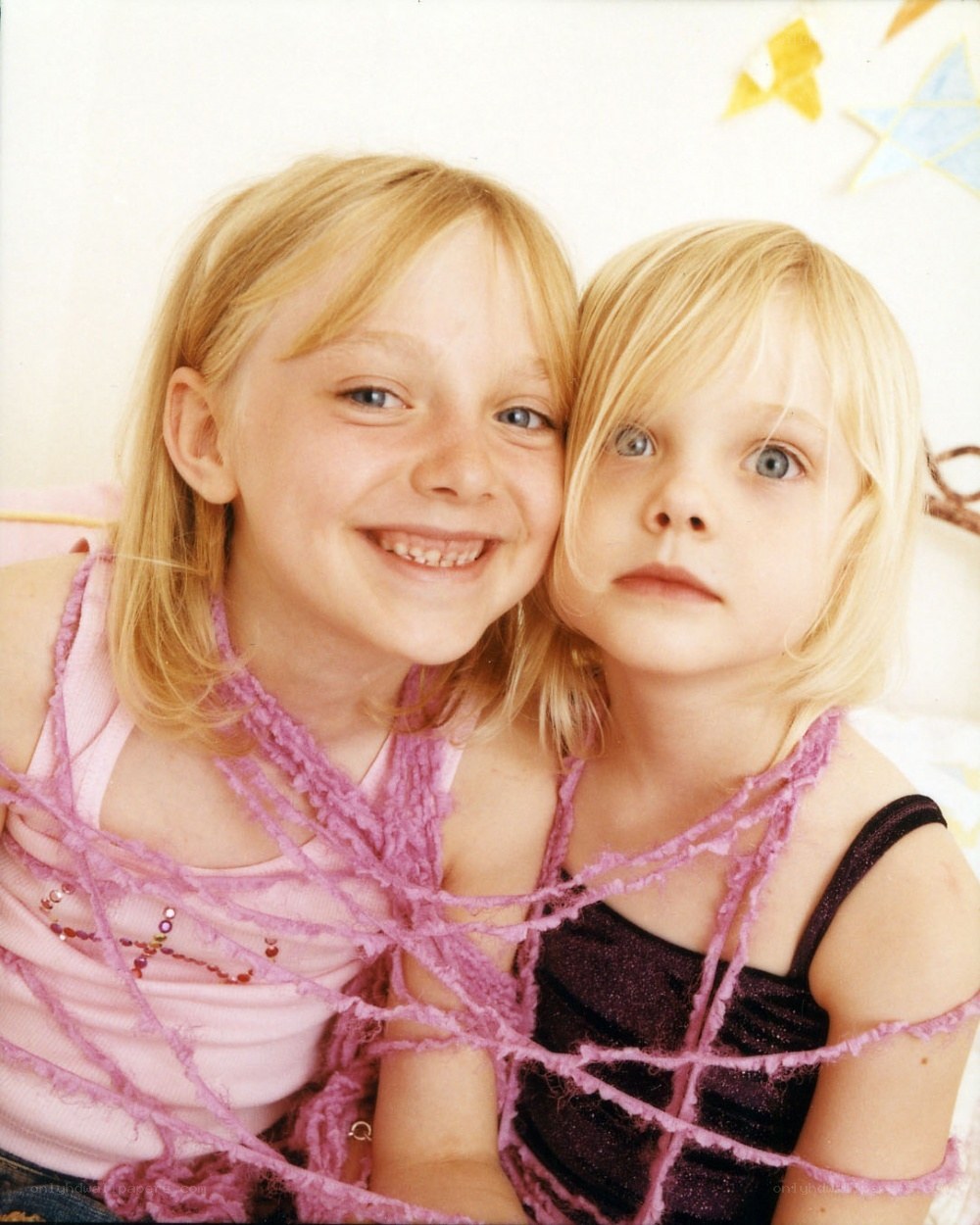 two girls wrapped in pink yarn