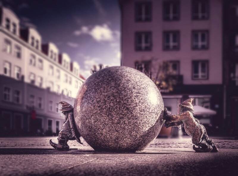 Two Gnomes Pushing Stone Ball