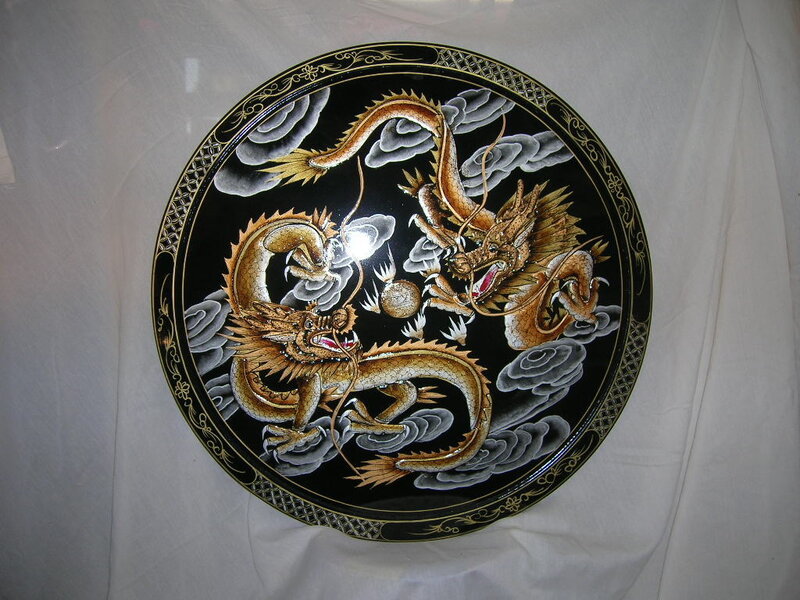 Two golden dragons on black plate