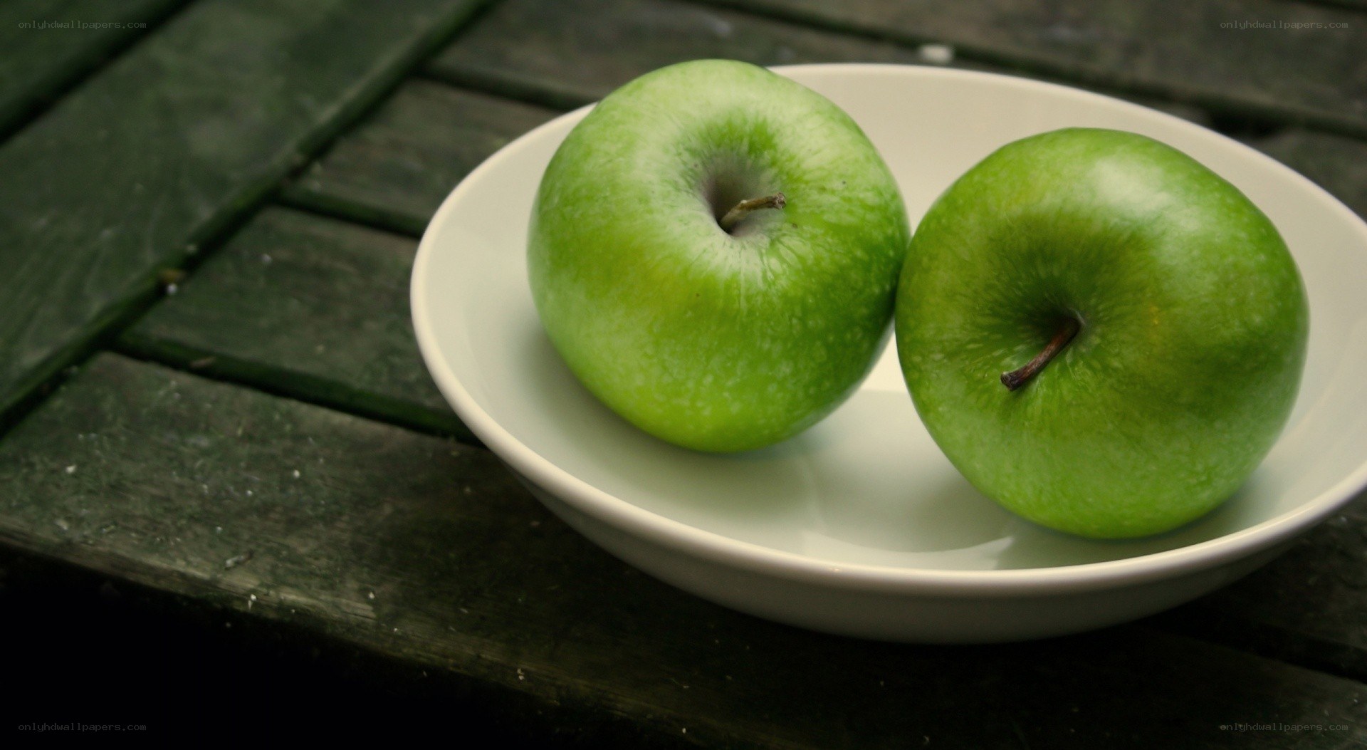 Two green apples on a plate