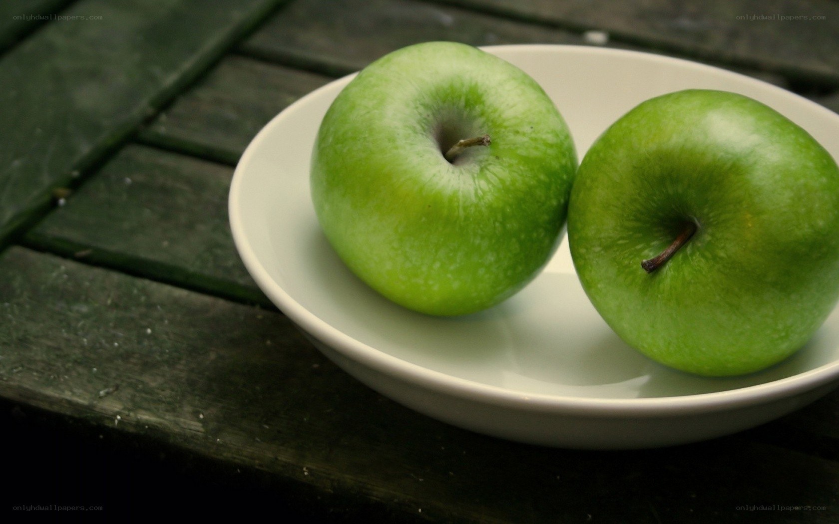 Two green apples on a plate