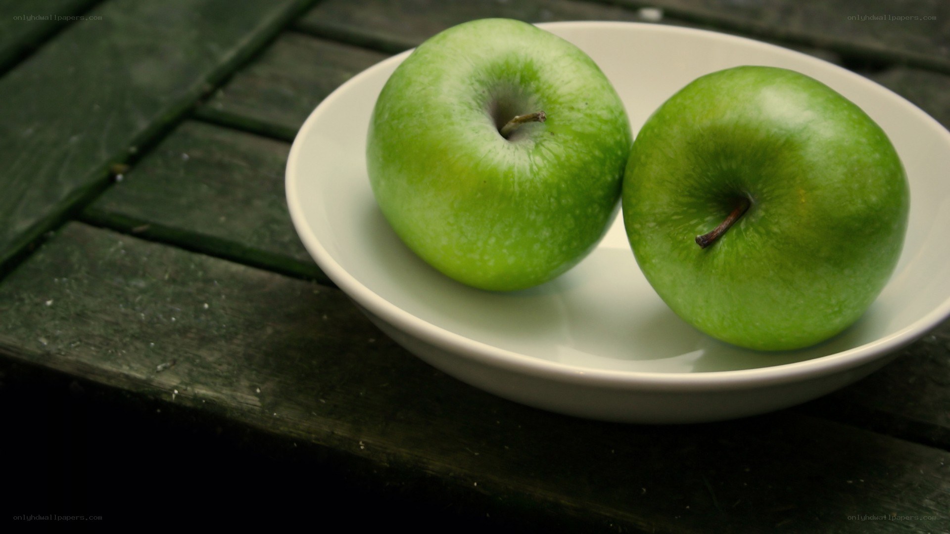 Two green apples on a plate