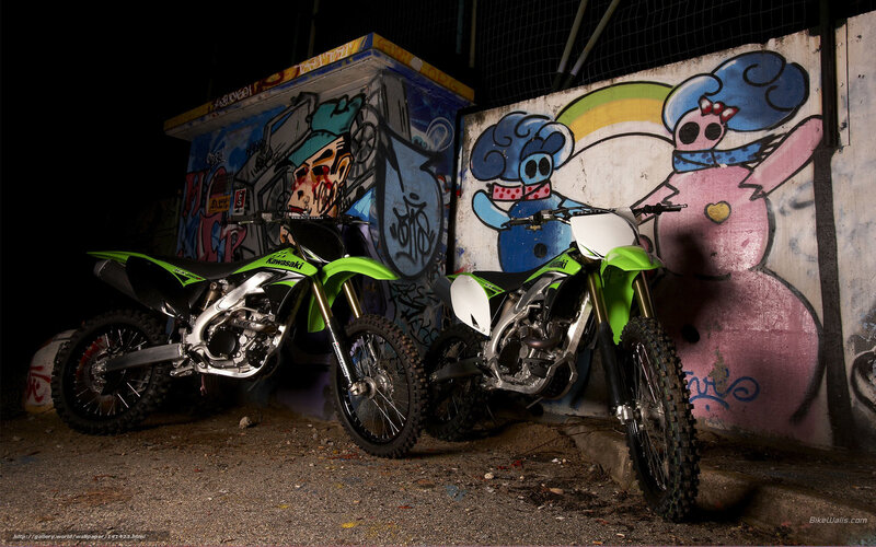 Two green dirt bikes in alley