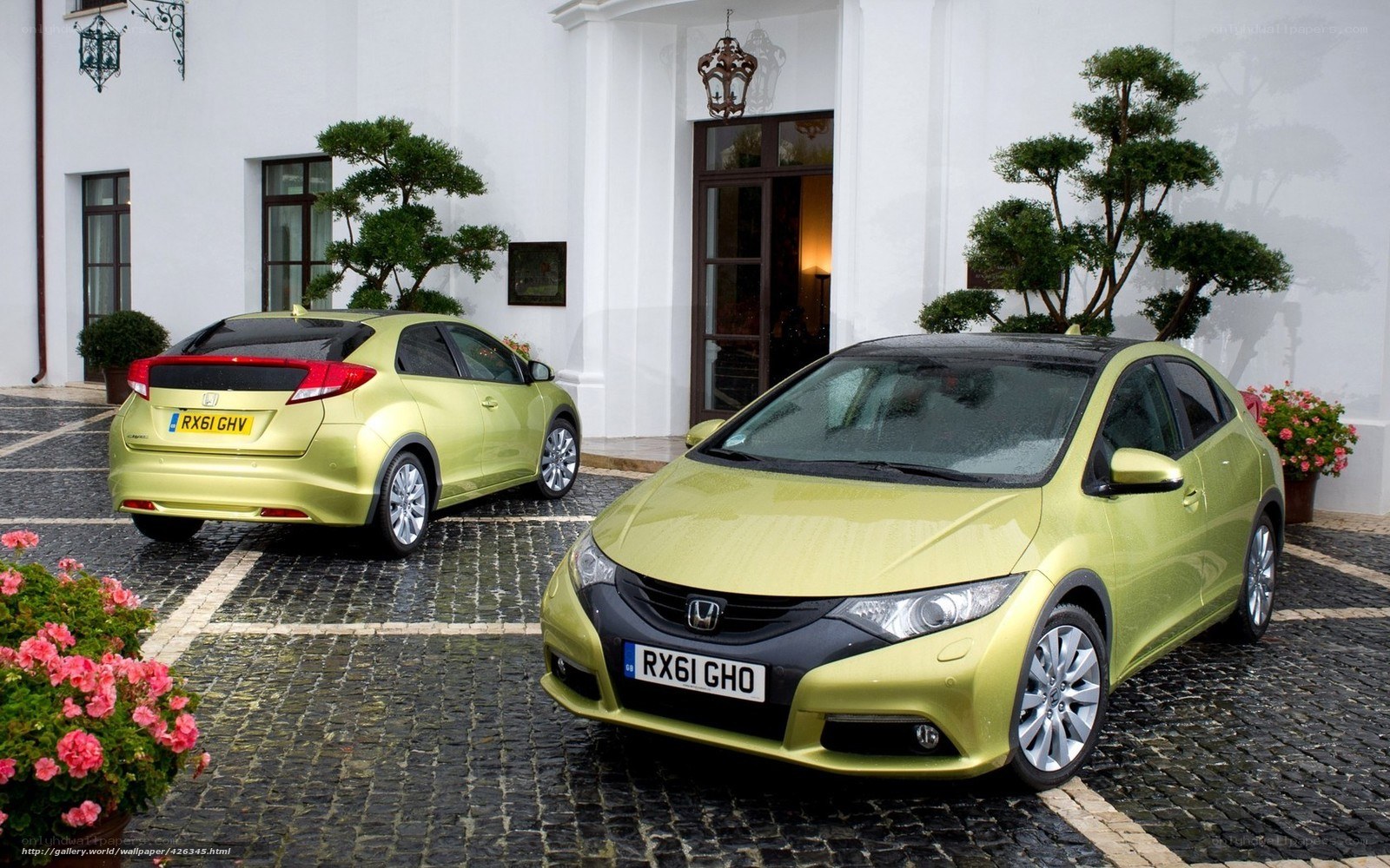 Two green Honda cars on cobblestones