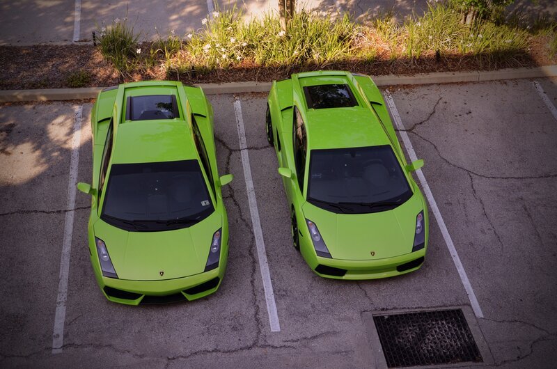 Two green Lamborghinis parked