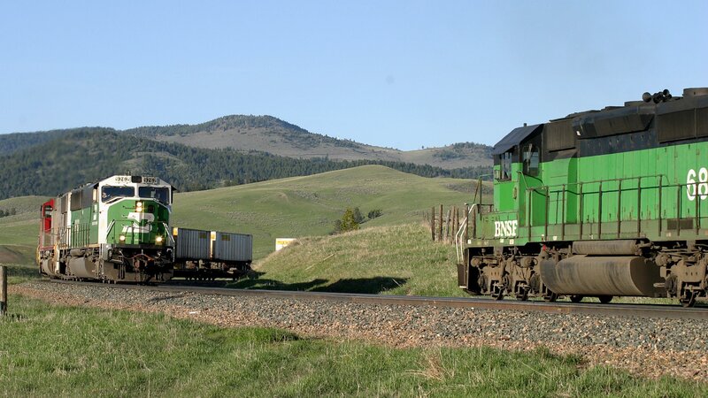 Two green trains on parallel tracks
