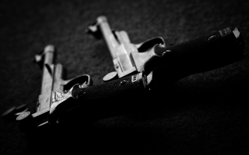 Two Handguns on Surface — Black