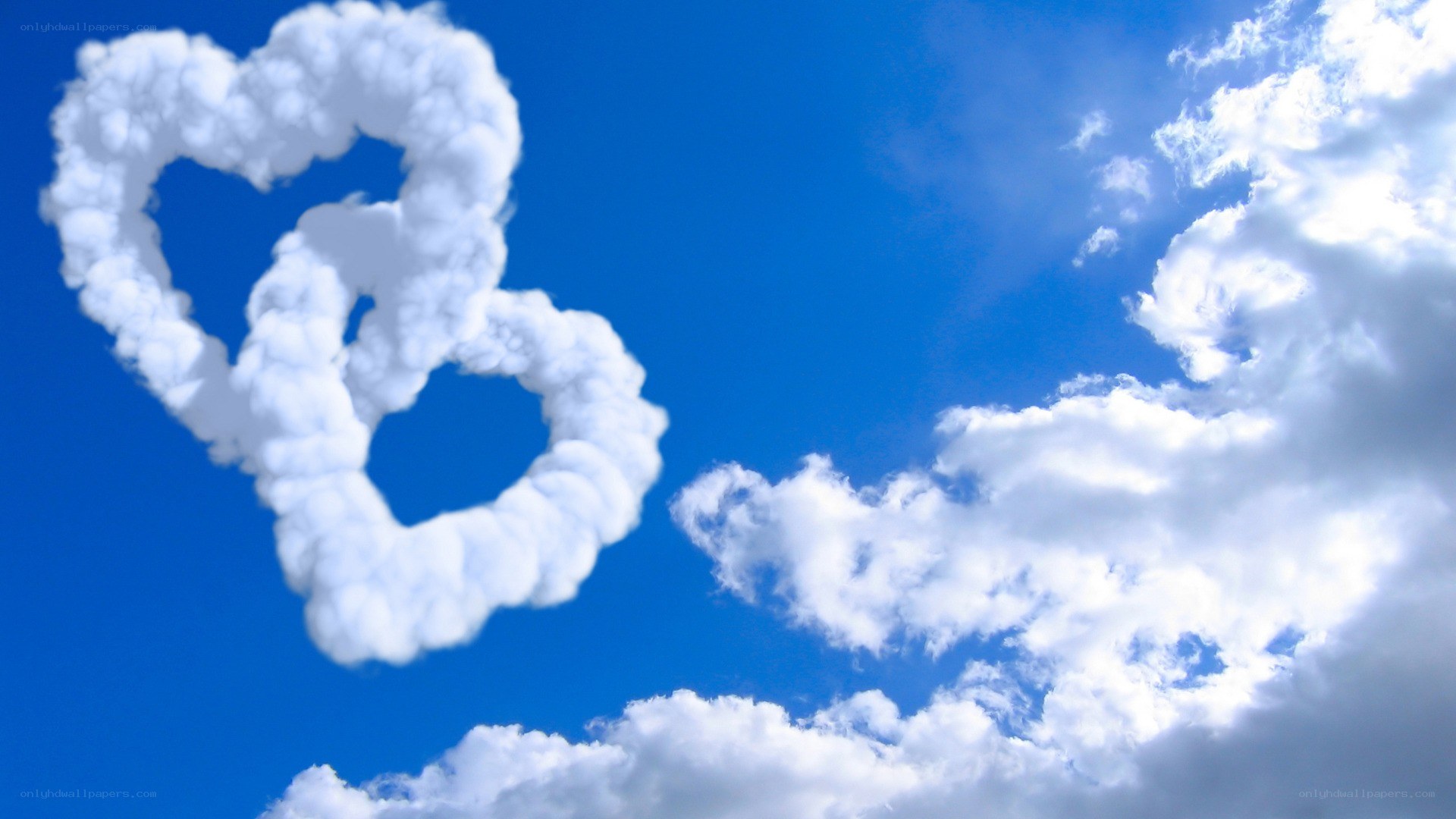 Two heart-shaped clouds in blue sky