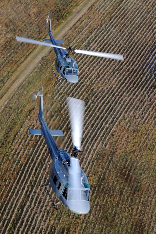 Two helicopters over a field