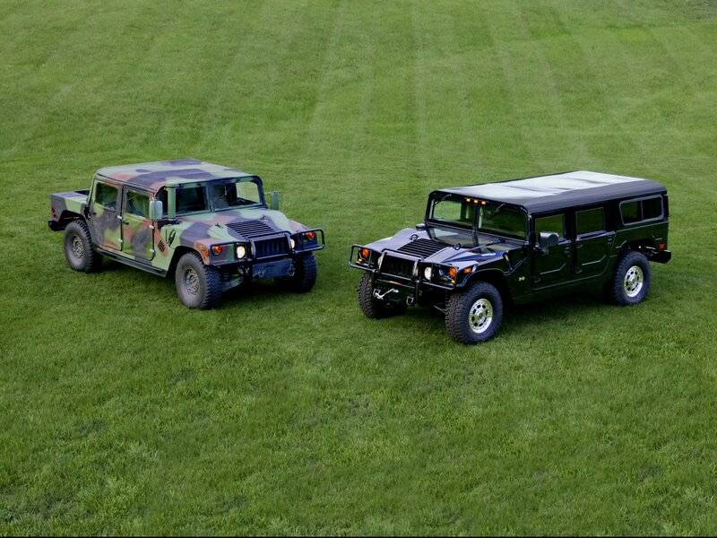 Two Humvee vehicles on grass