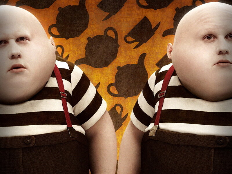 two identical bald boys in striped shirts