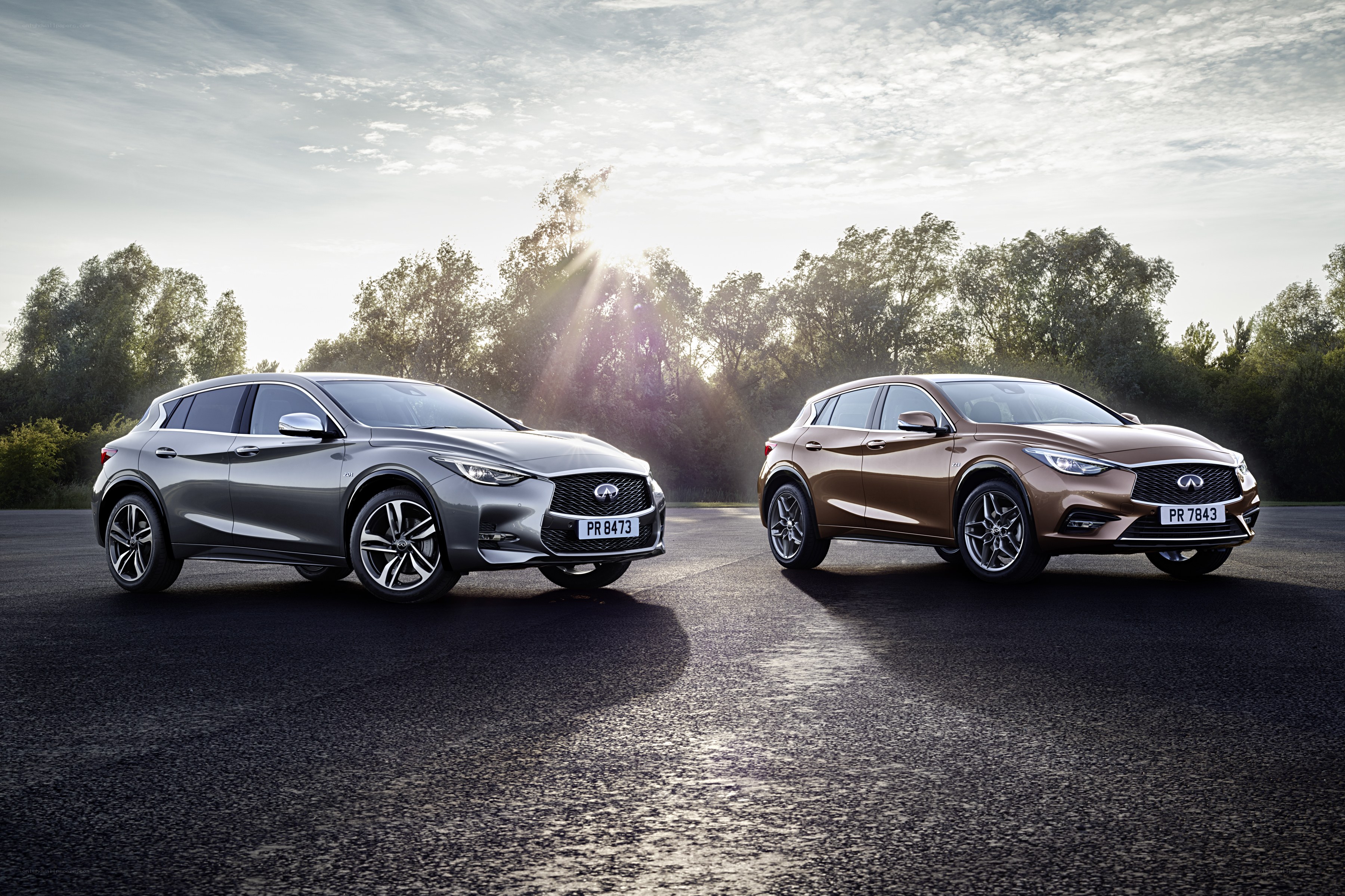 Two Infiniti cars on asphalt