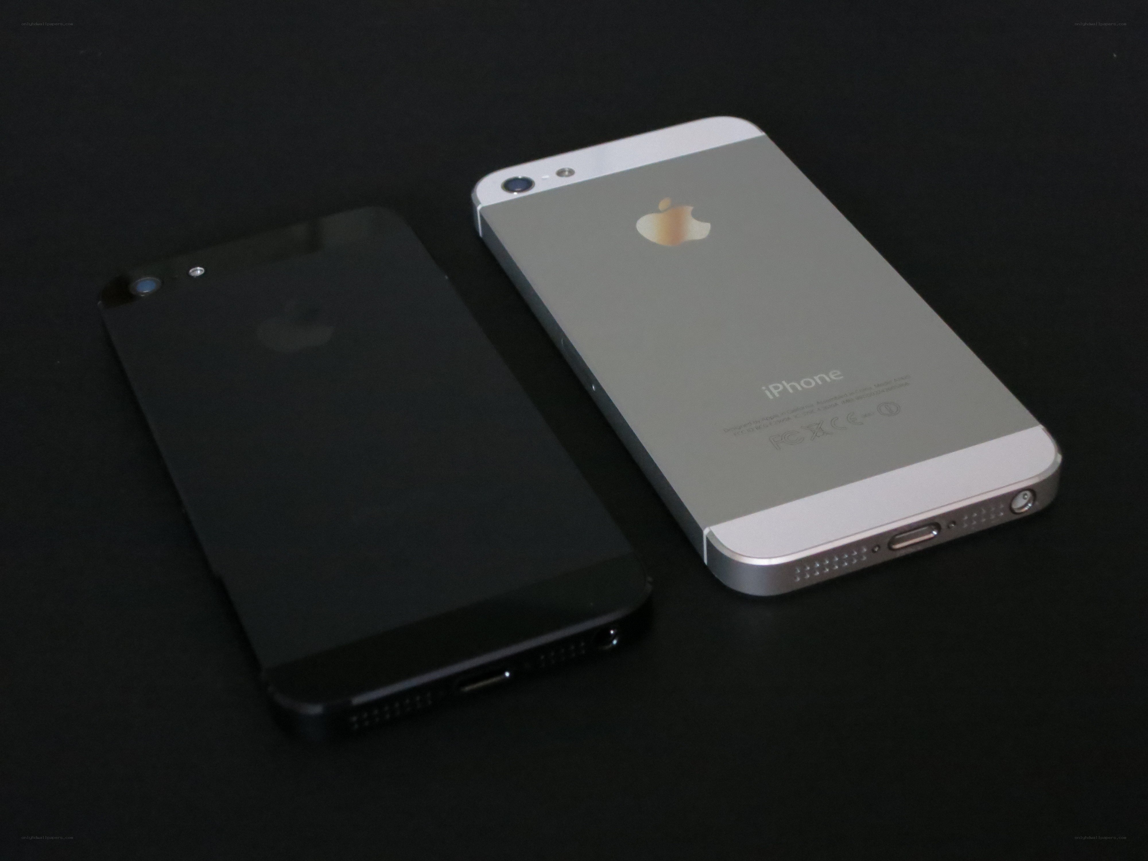Two iPhones on black surface