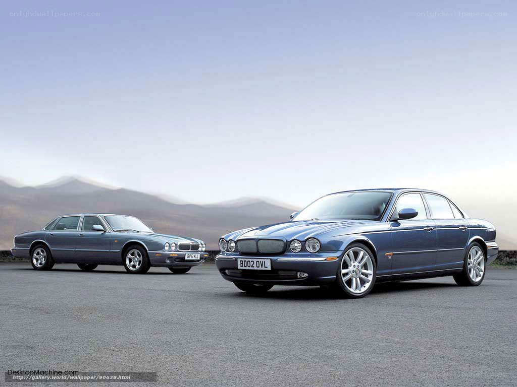 Two Jaguar sedans on a road