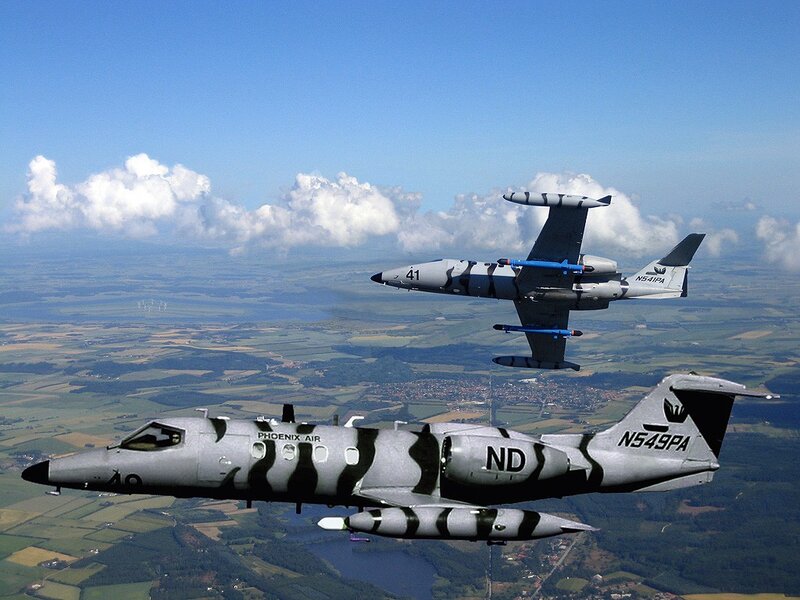 Two jets in flight over landscape