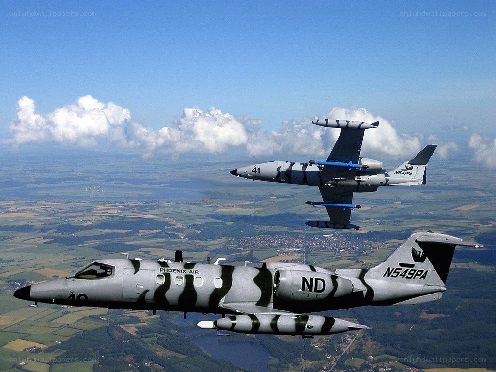 Two jets in flight over landscape