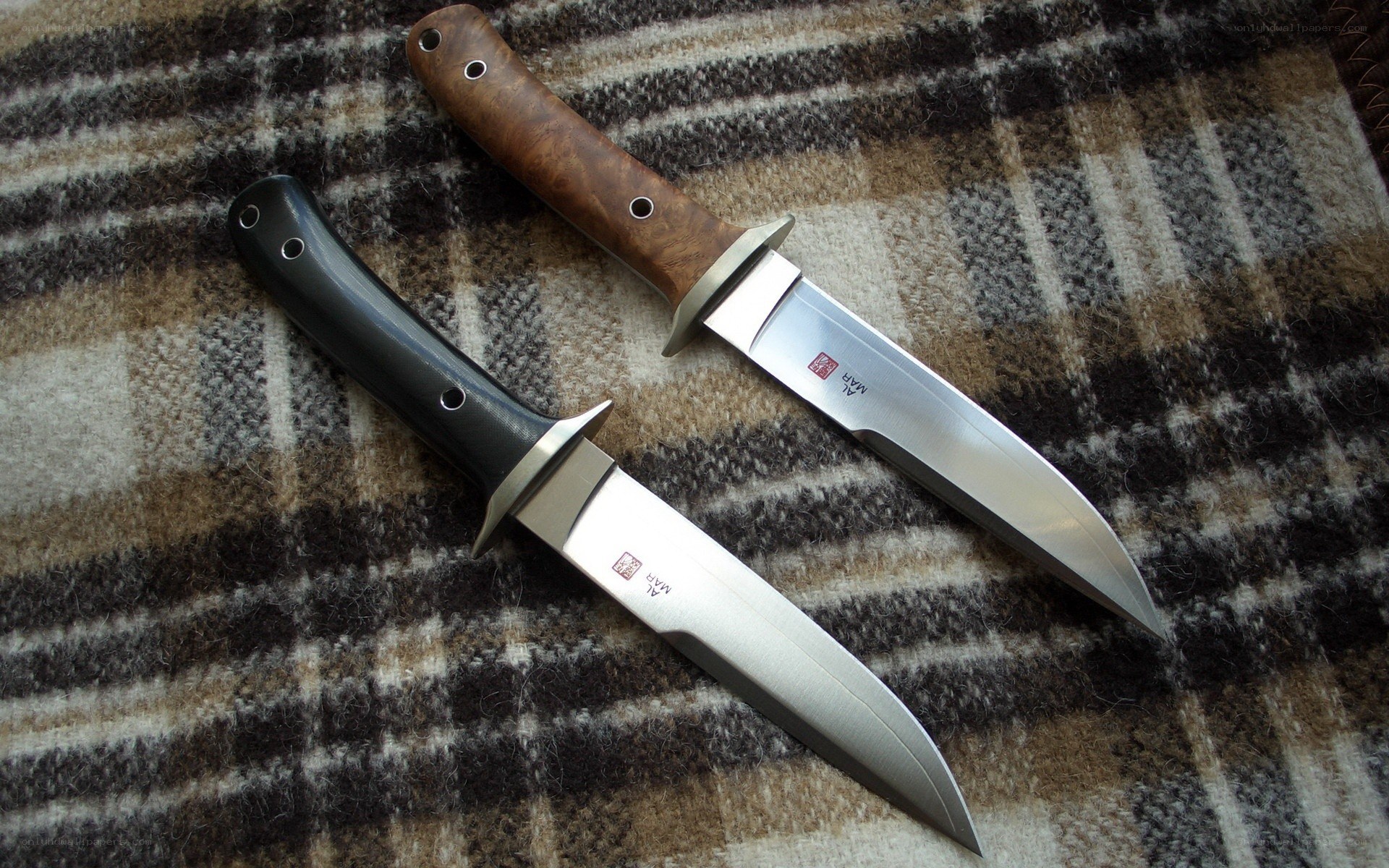 Two knives on a plaid blanket