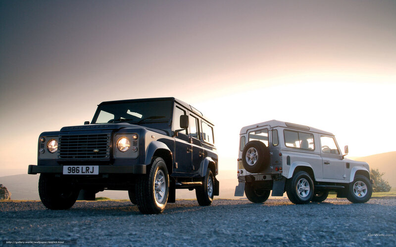 Two Land Rover Defenders at sunset