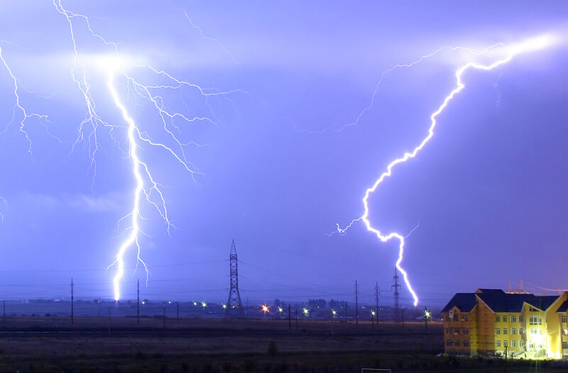 Two lightning strikes over landscape