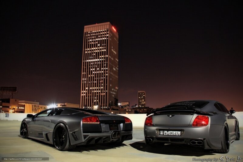 Two luxury cars at night