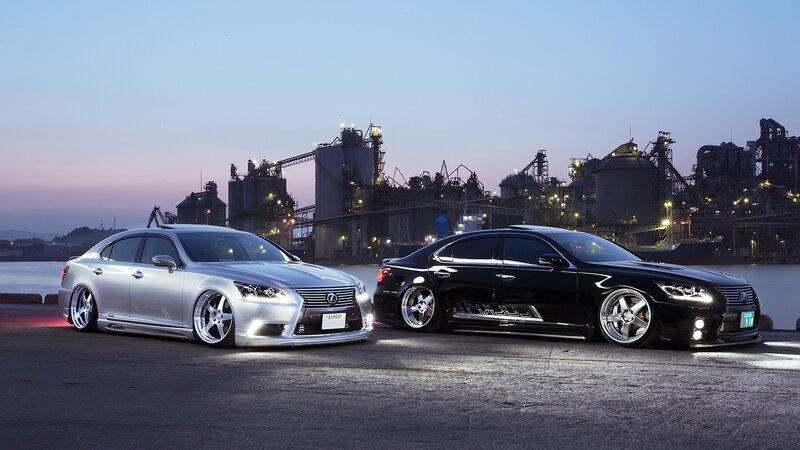 Two luxury sedans at industrial port