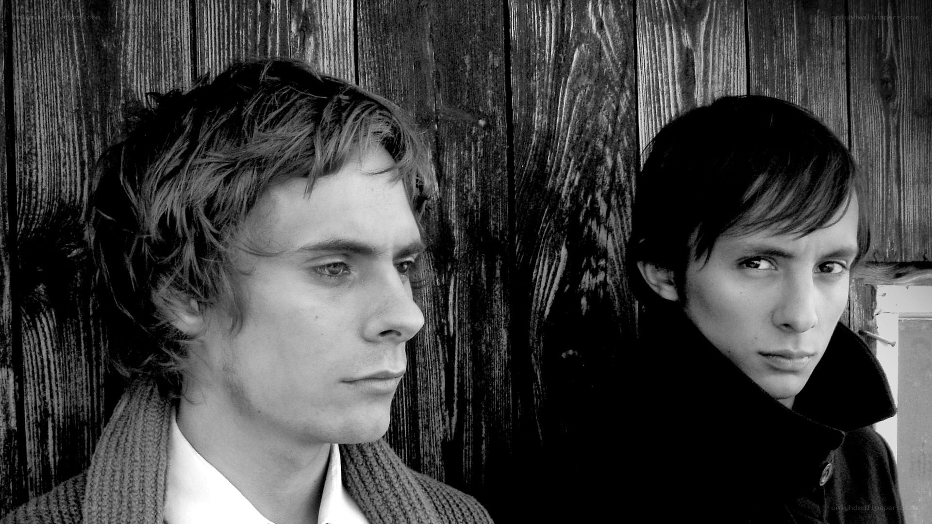 two men against wooden wall