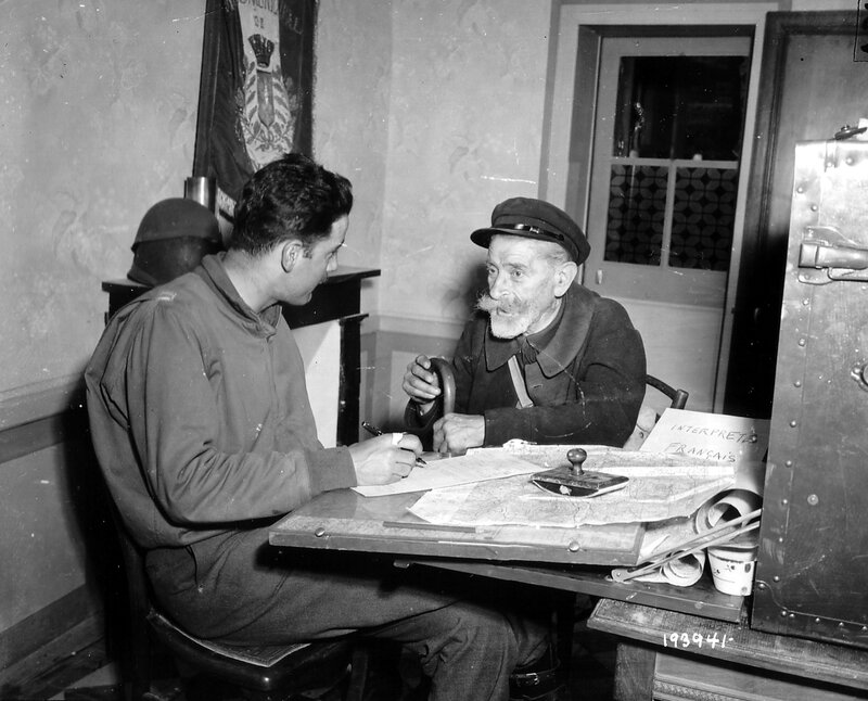 Two men at a desk with maps