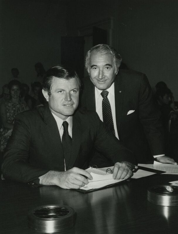 Two men at a table signing documents